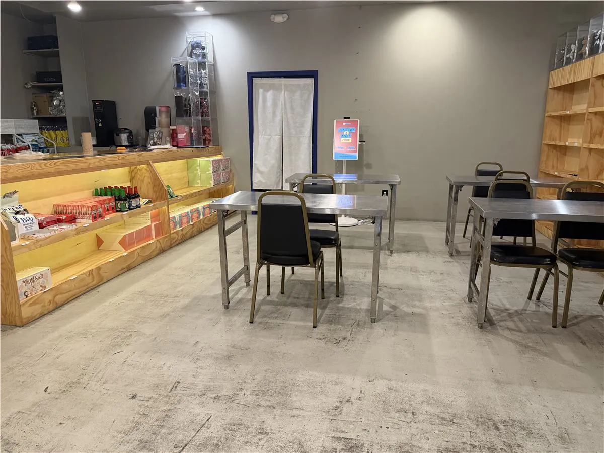 Tiger Den dining area with metal tables, wooden shelves, product display, and order kiosk